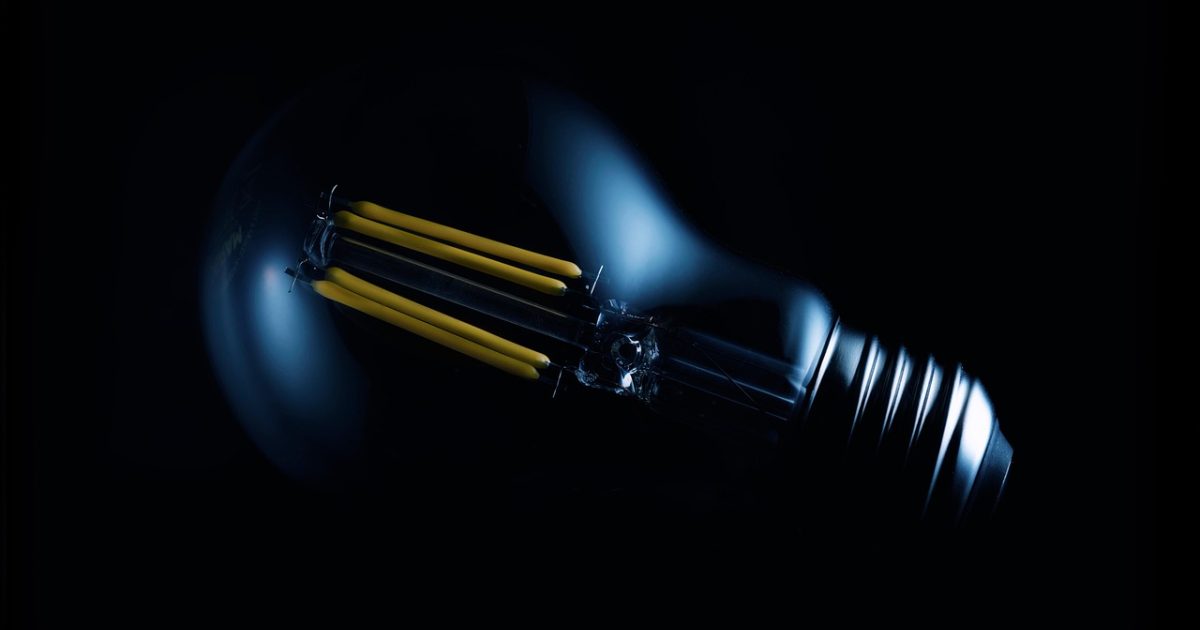 电竞玩家三人围坐在显示器前观看虎扑电竞赛事直播回放，桌上摆着饮料与笔记本，暖色台灯下气氛专注热烈